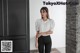 a woman standing in front of a black door