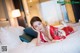 A woman in a red kimono laying on a bed.