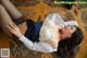A woman laying on the floor in a white shirt and black stockings.