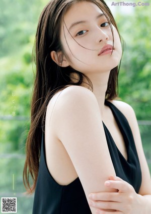A woman in a black dress posing for a magazine.