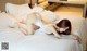 A woman laying on a bed in a white lingerie.