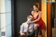 A man and a woman sitting on a chair with a mask on.